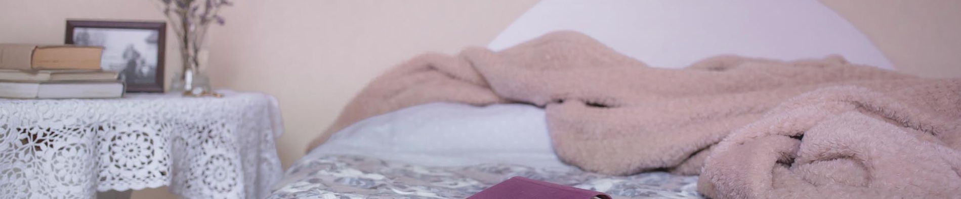 Prothetik - zu sehen ist ein Bett mit aufgeschlagener Bettdecke, ein Buch und ein Nachttischchen mit weiteren Büchern